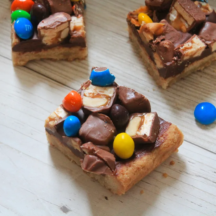 Leftover Halloween Candy Bars have a shortbread base, a layer of gooey melted chocolate chips, and then all the Halloween candy you can throw at 'em. How could that be a bad thing?